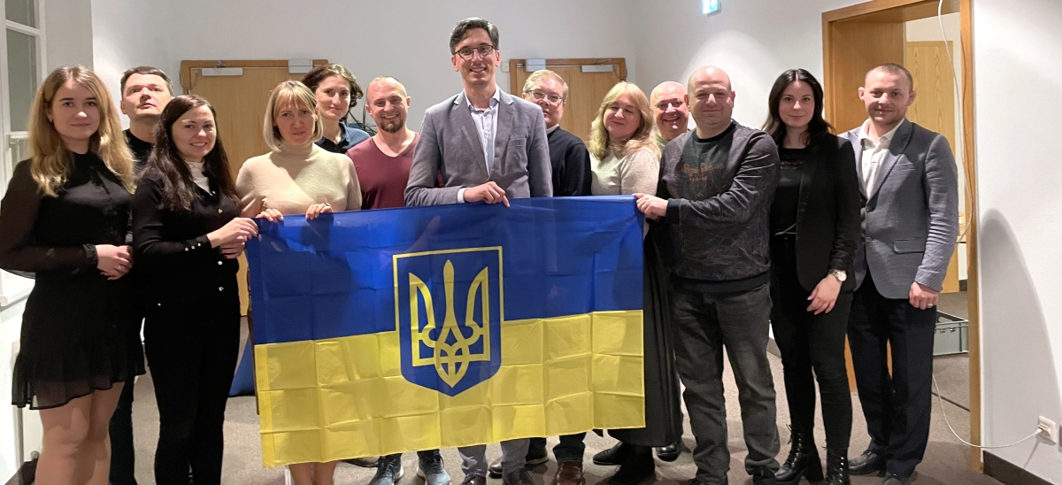 Die ukrainische Delegation mit der Landesflagge und IHK-Hauptgeschäftsführer André Fritsche