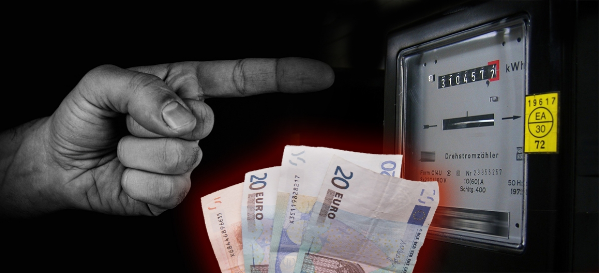 Eine Hand zeigt auf einen Stromzähler, Geldscheine im Vordergrund